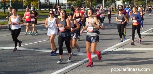 Group of women running marathon together - photo by popular fitness