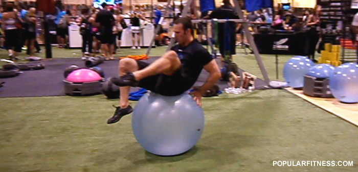 Man exercising using an exercise ball - photo by popular fitness