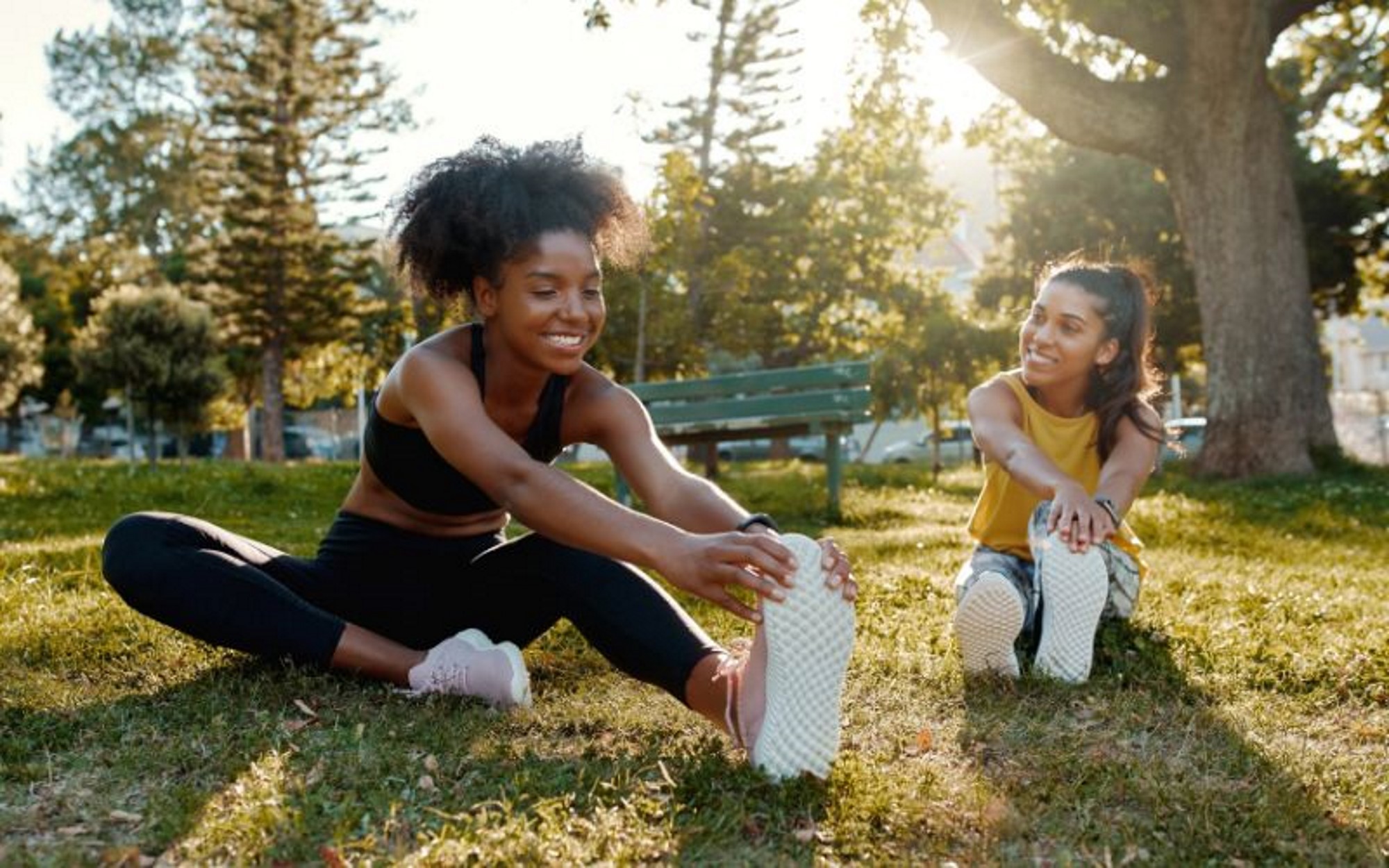 2 women warming up and stretching at a park