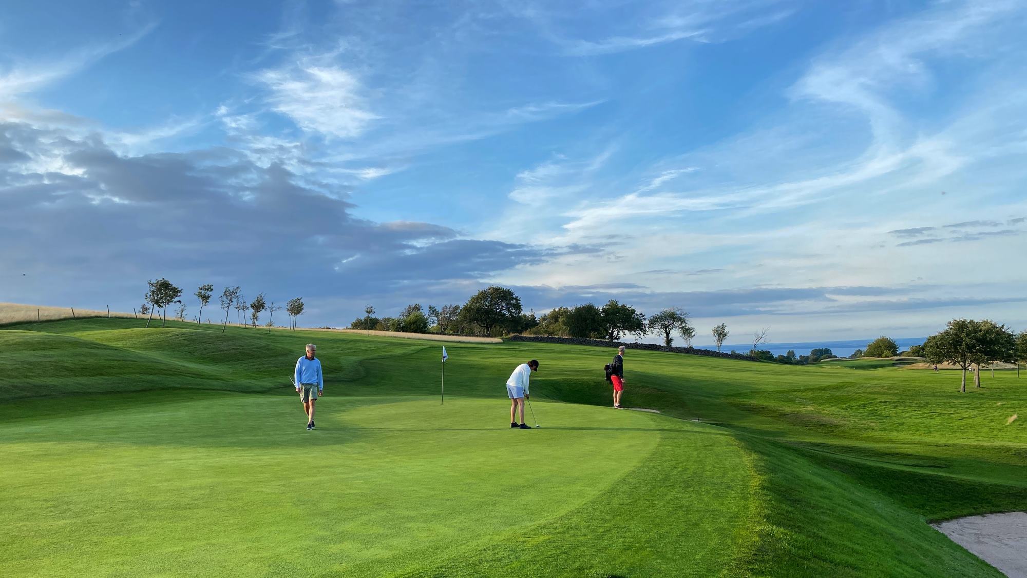 3 golfers playing golf on at a beautiful golf course