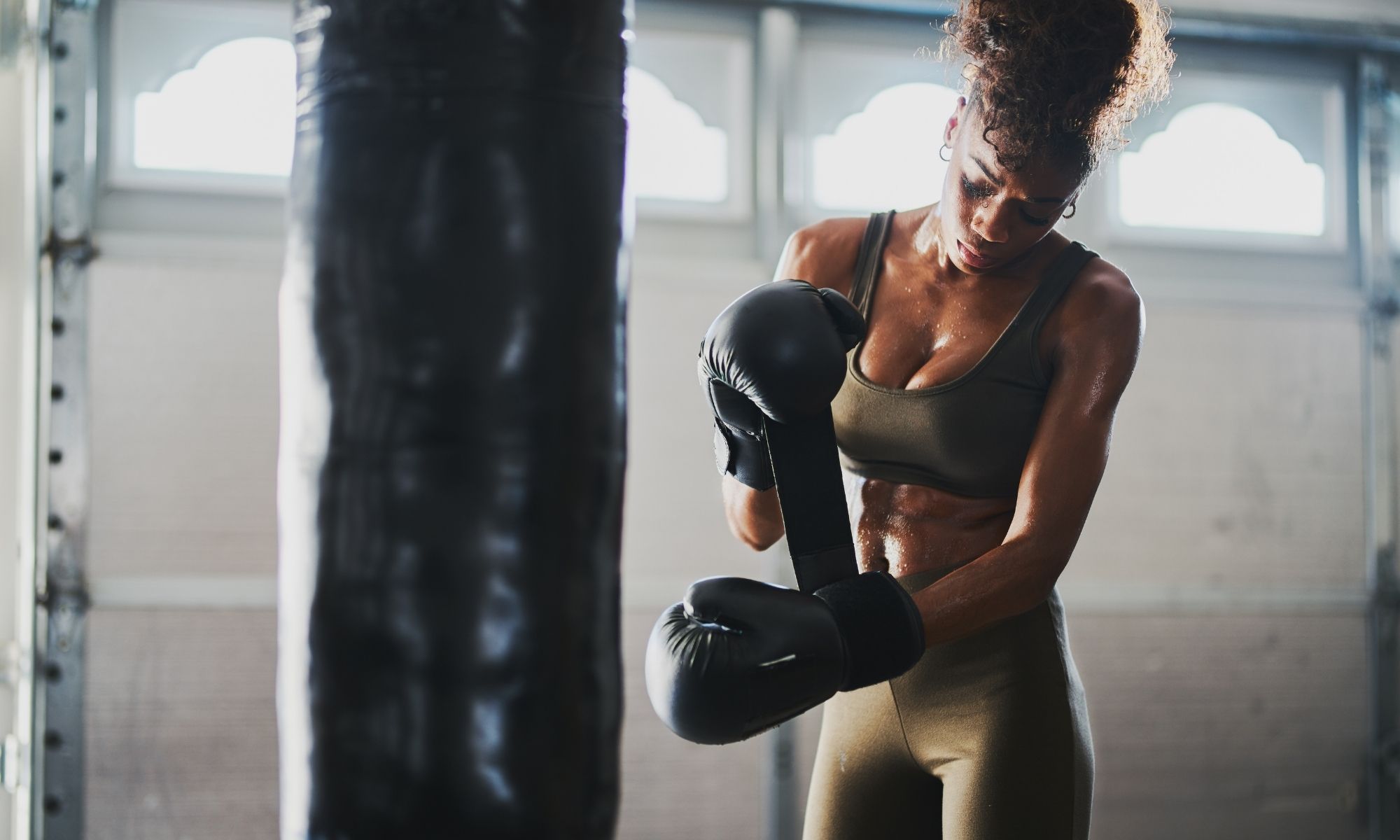 Beautiful woman in her workout clothing boxing, exercising.