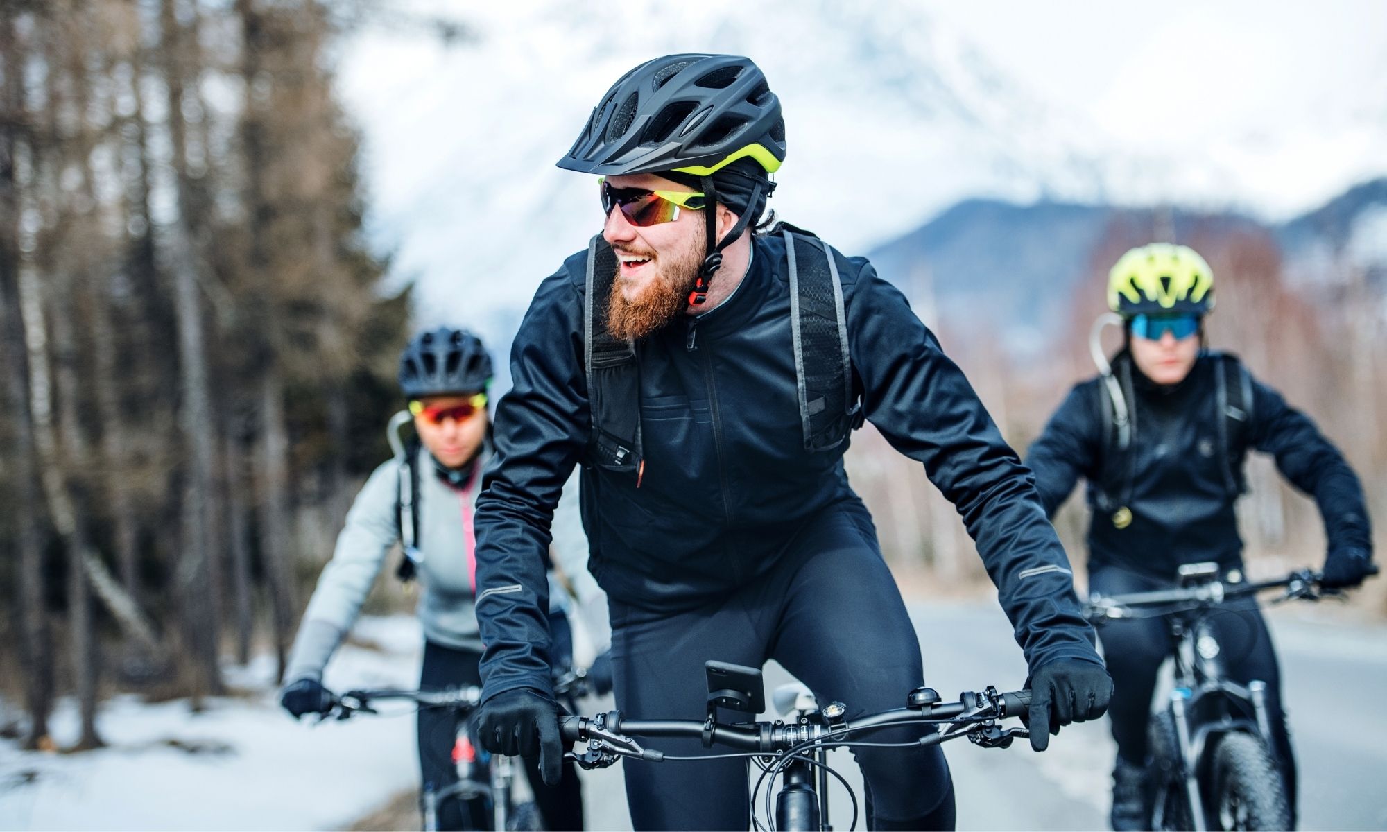 3 cyclists biking outside in winter