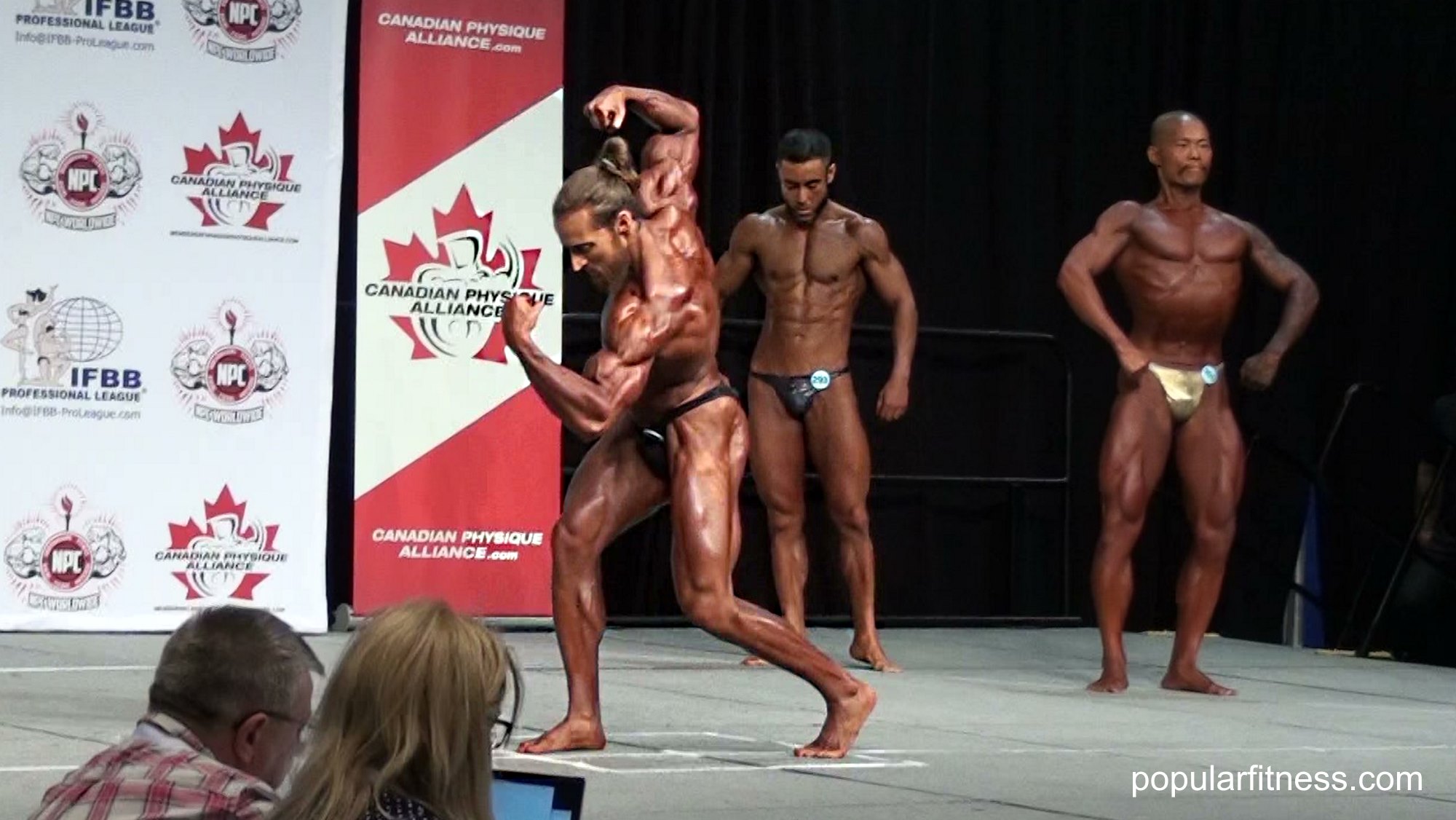 Beautiful biceps pose by bodybuilder at bodybuilding fitness competition