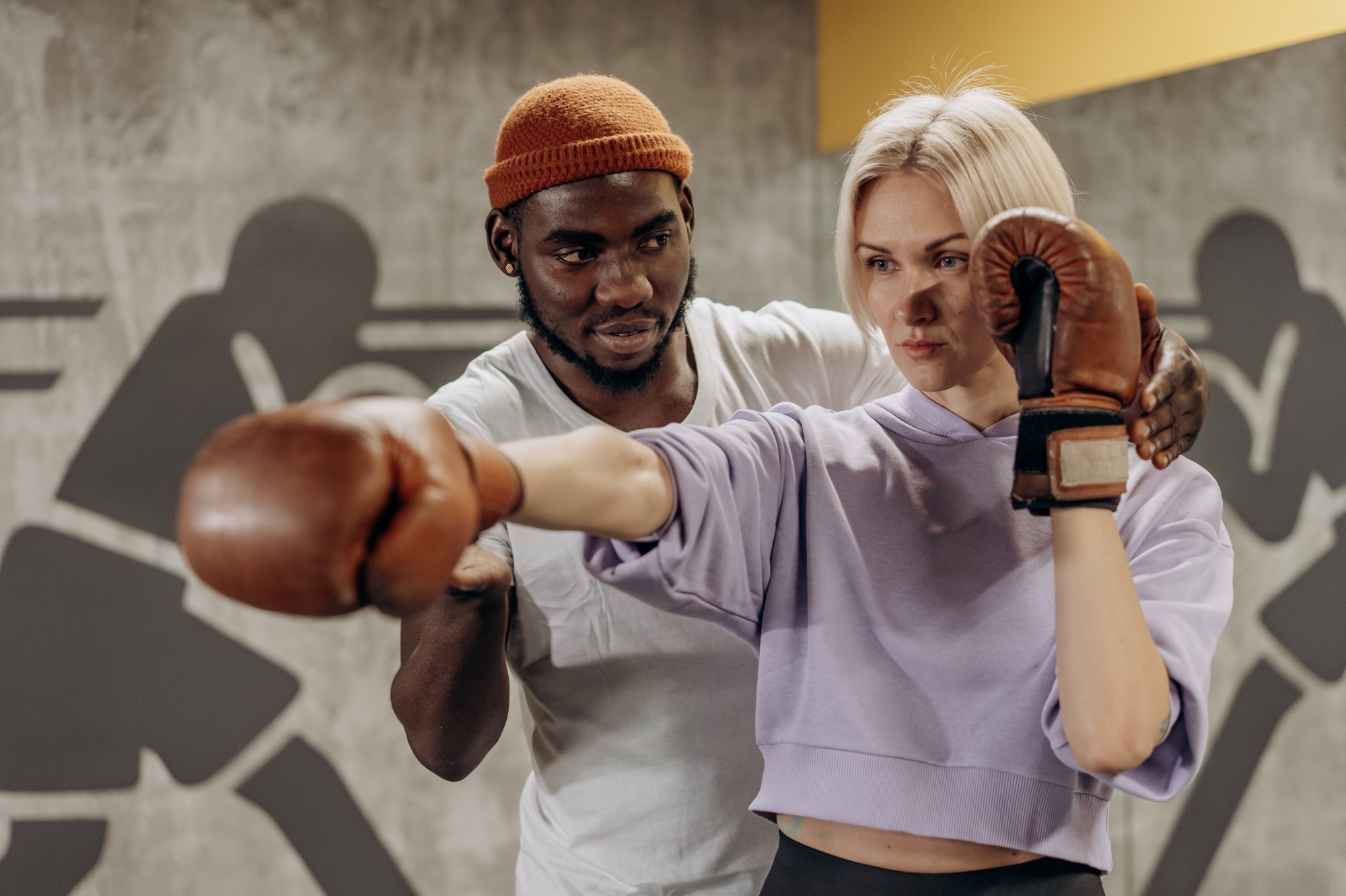 Trainer teaching woman to box - boxing workout.