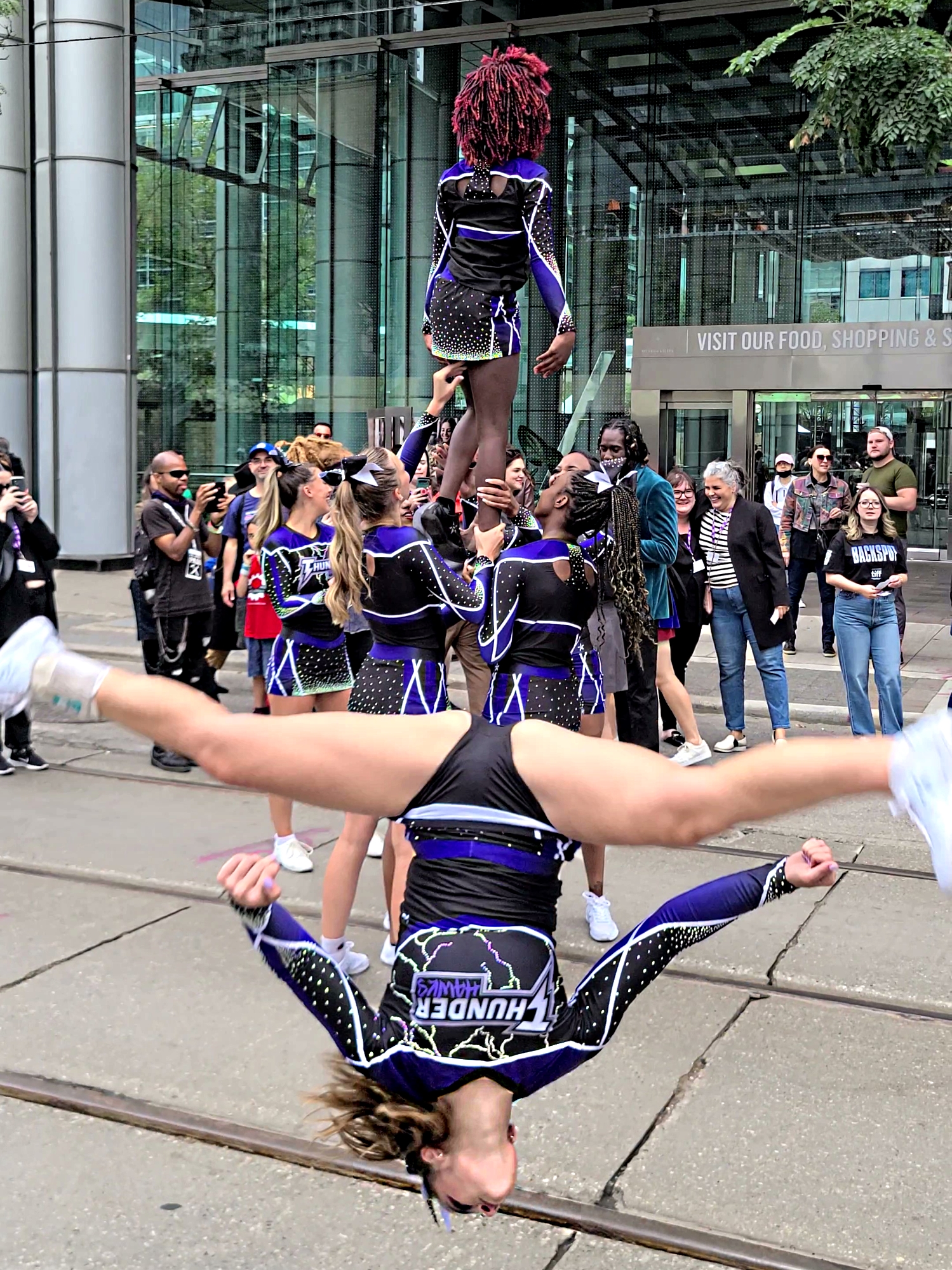 Cheerleader performing an upside down somersault split