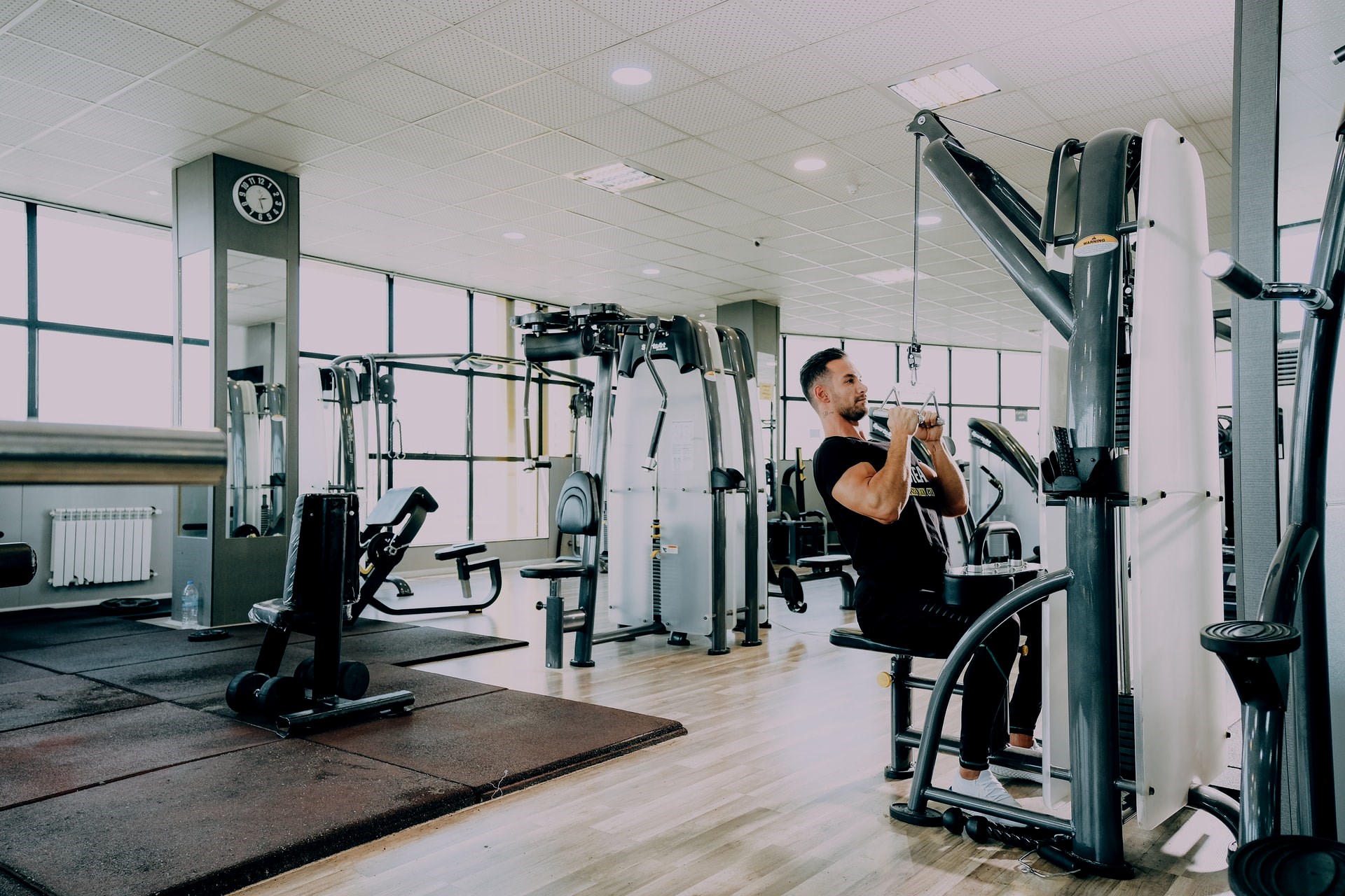 Man using exercise machine to do close grip lat pulldown back exercise