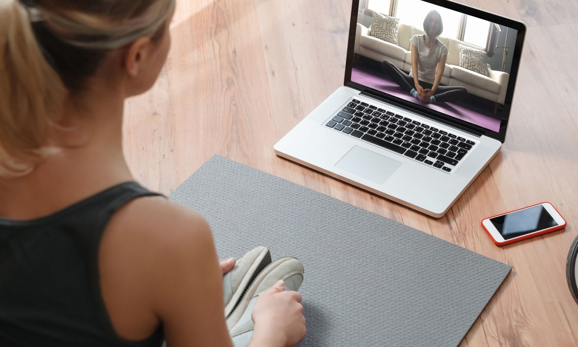 Woman exercising to an online exercise program on her laptop