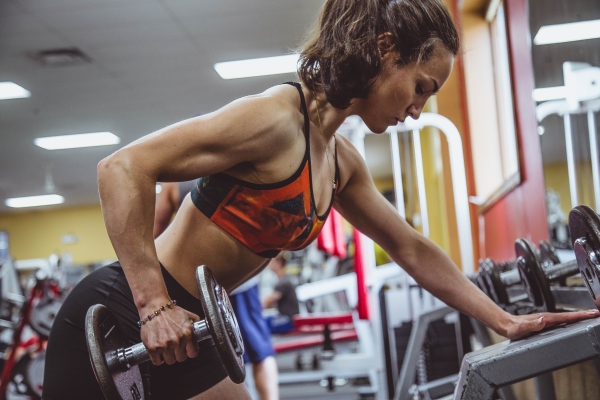 Woman doing the dumbbell row exercise at the gym