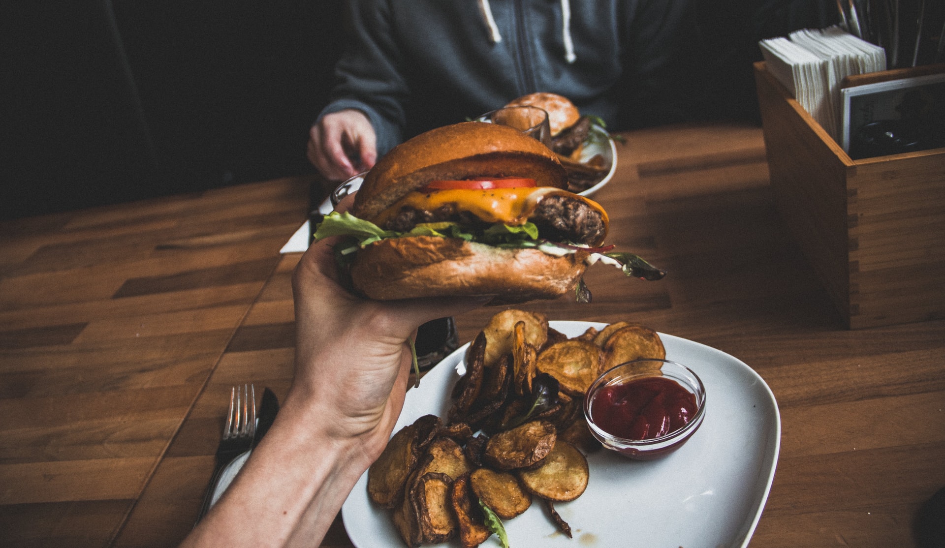 Person holding a big beef hamburger