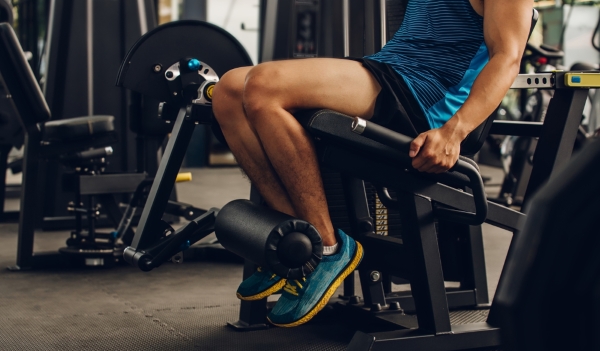 Man doing leg extension exercise at the gym