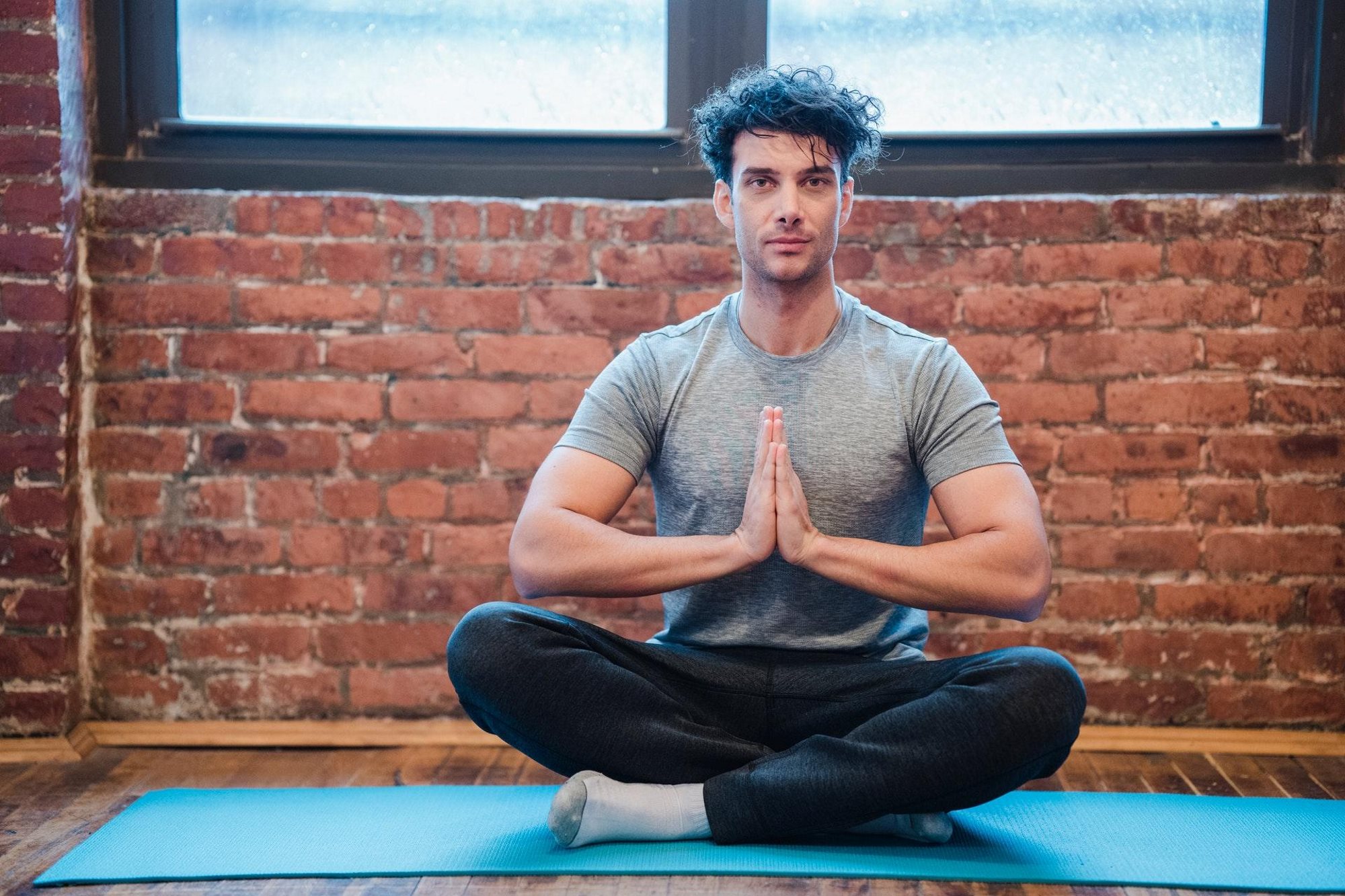 Man practising yoga and meditation - doing a yoga pose and meditating.