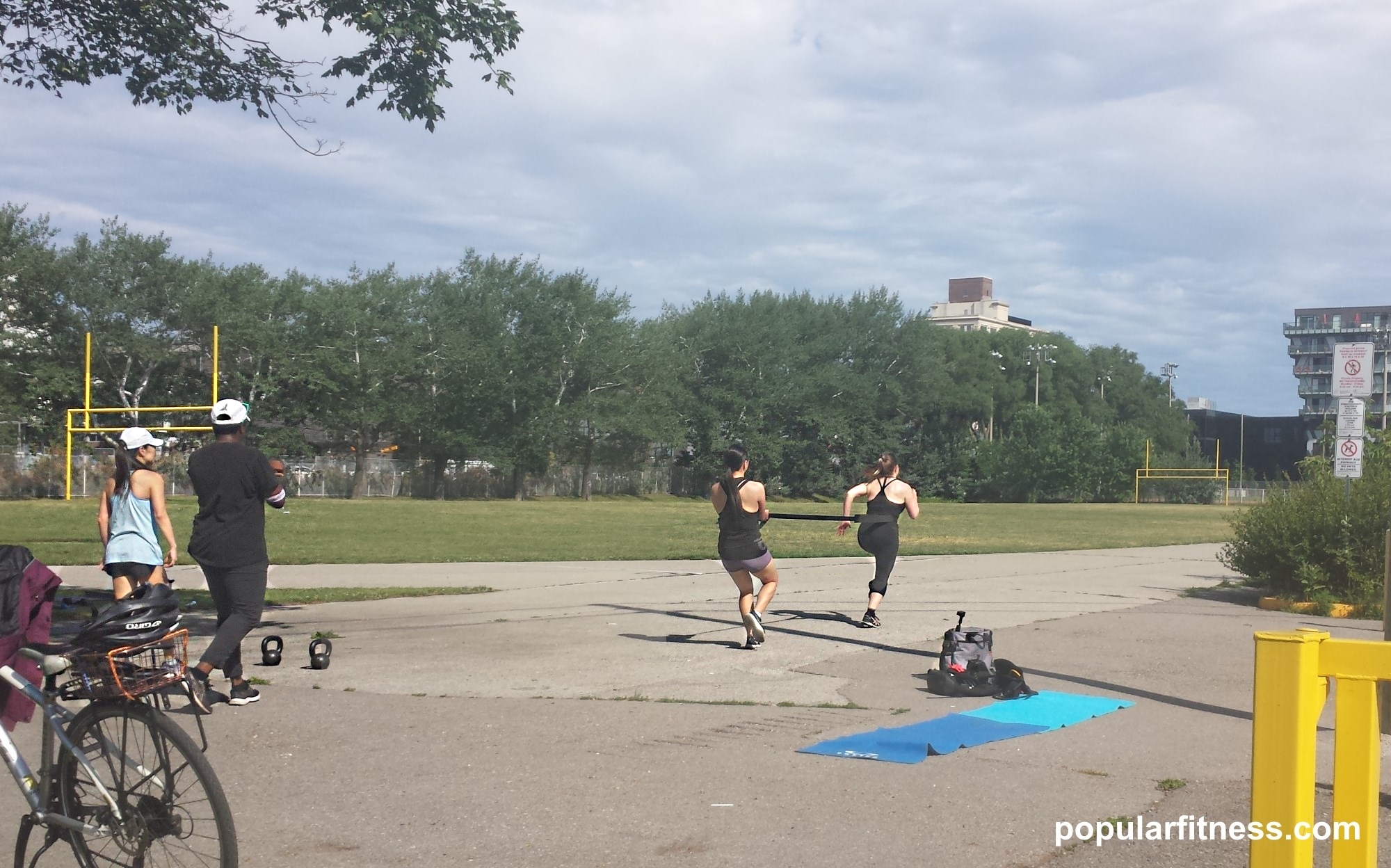 Women exercising outdoors in summer while being personally trained by a personal trainer - photo by popular fitness