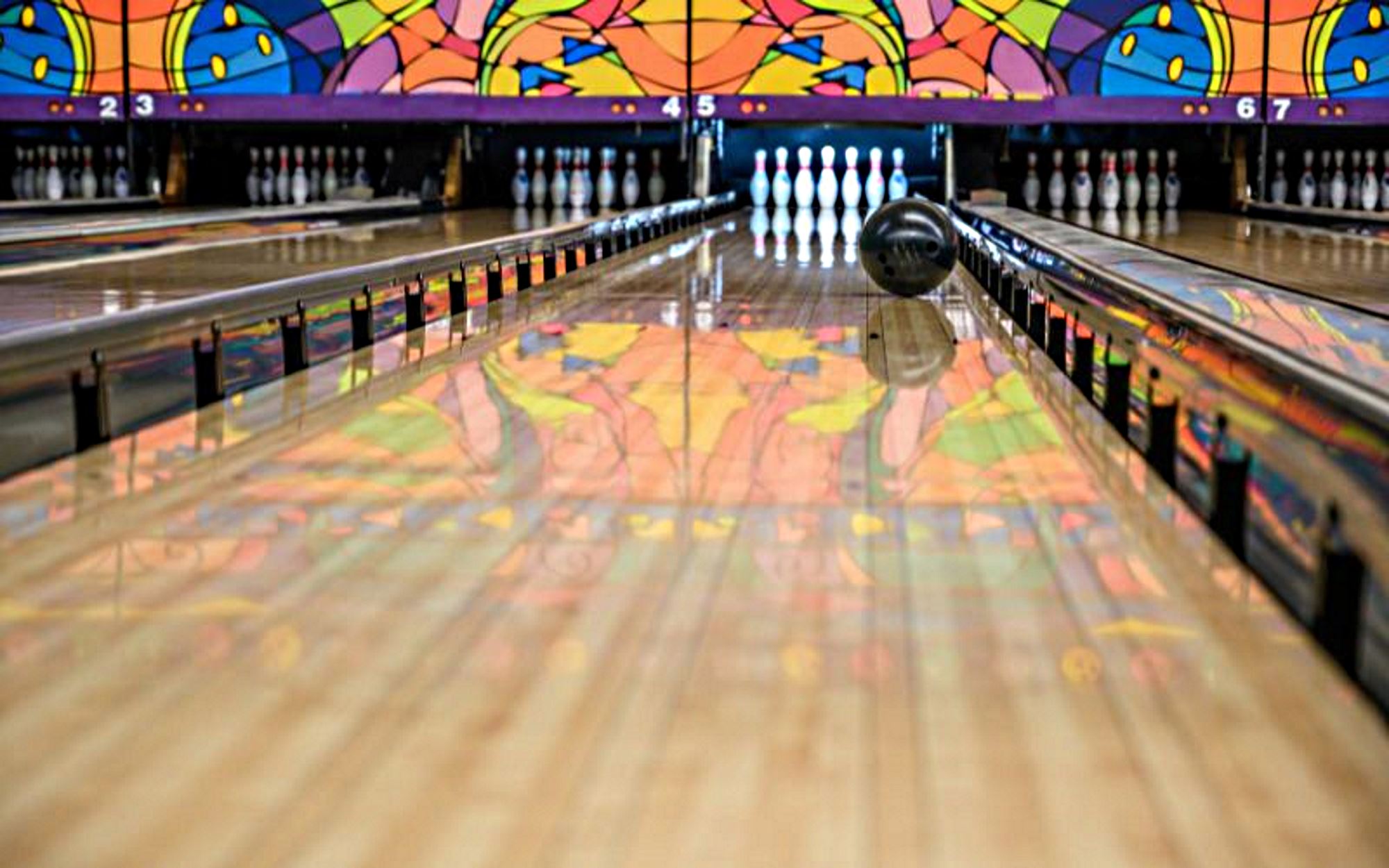 Bowling ball rolling down a bowling lane - sport of bowling.