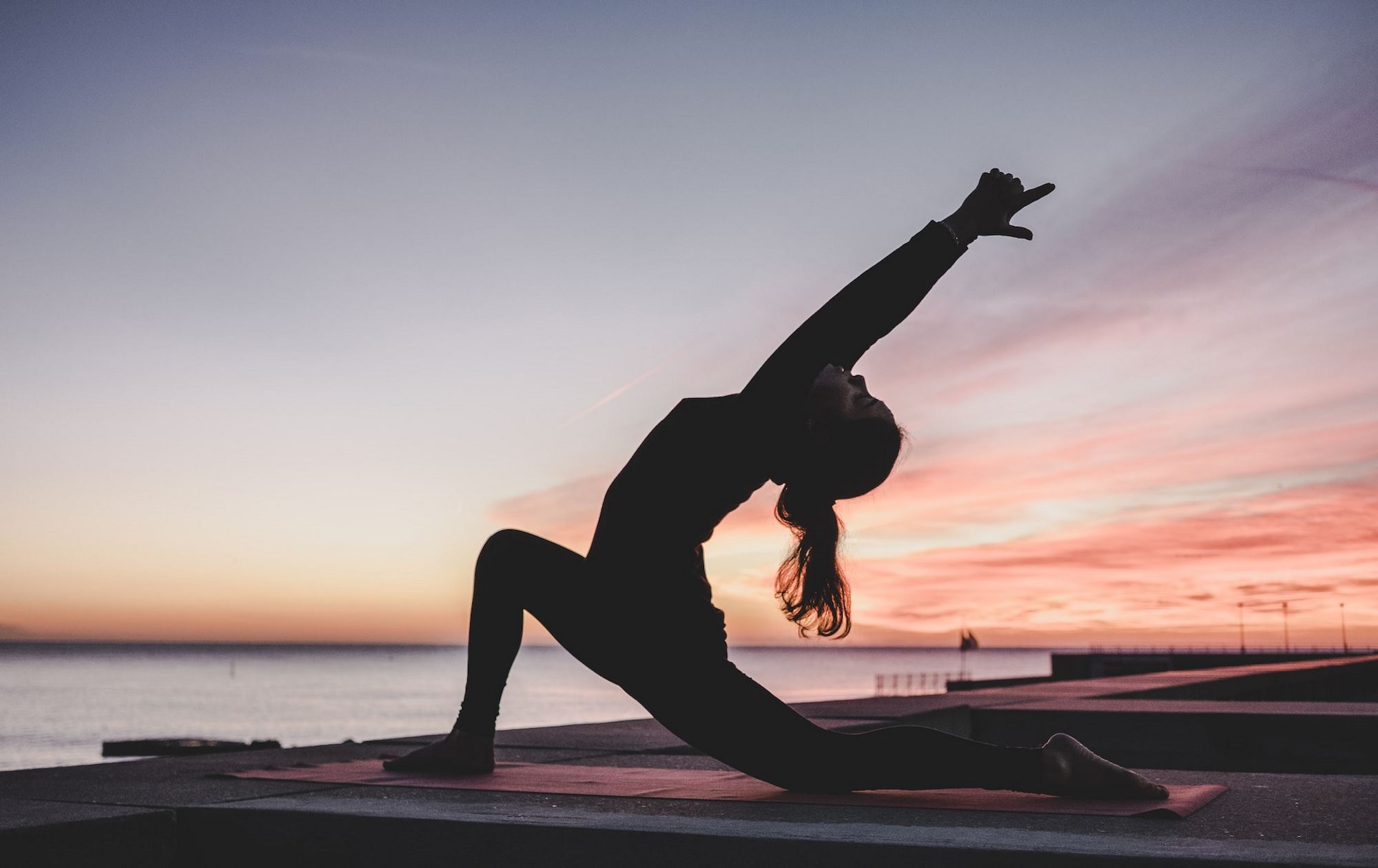 Woman doing yoga during a sunset