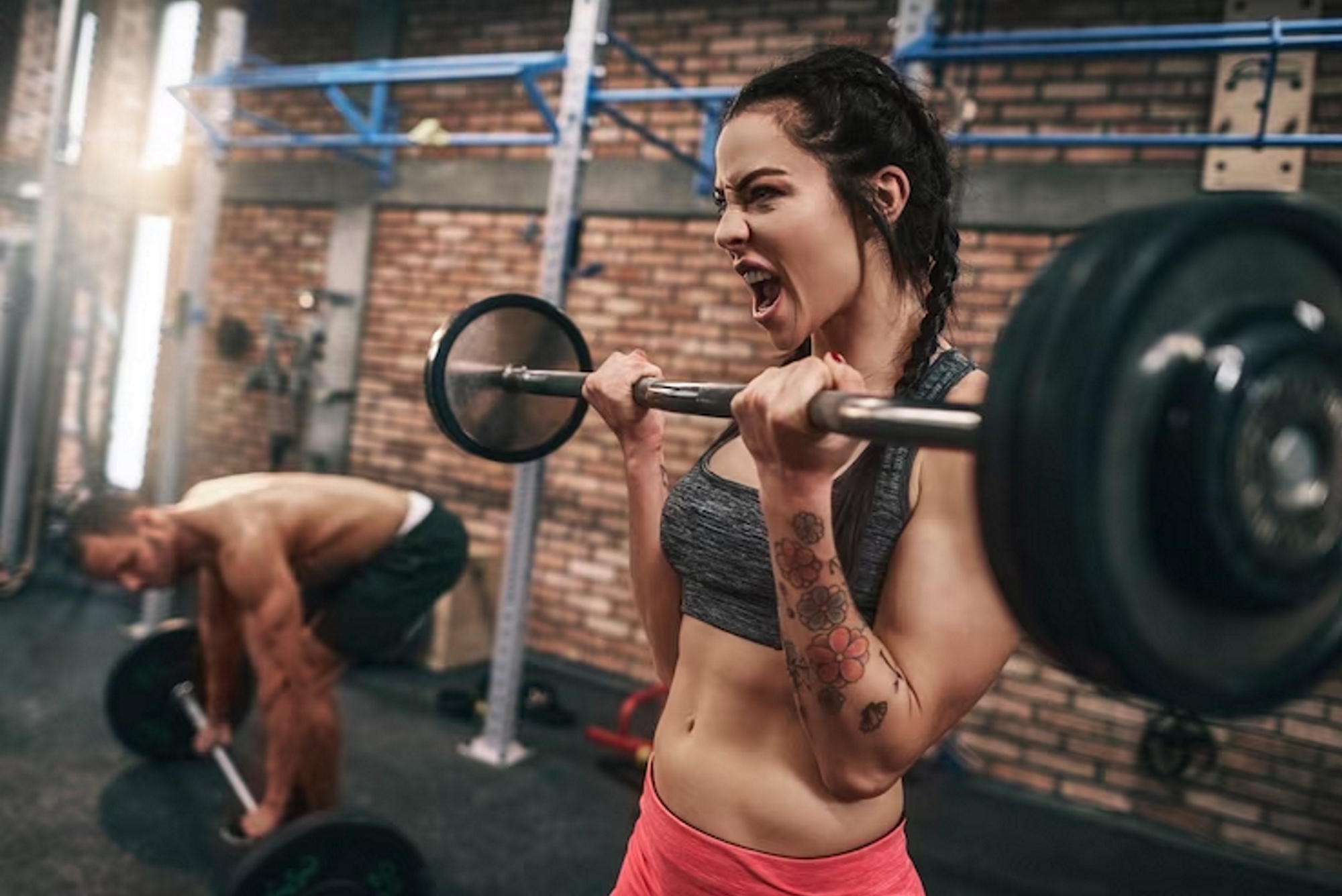 A woman and a man weight training with barbells