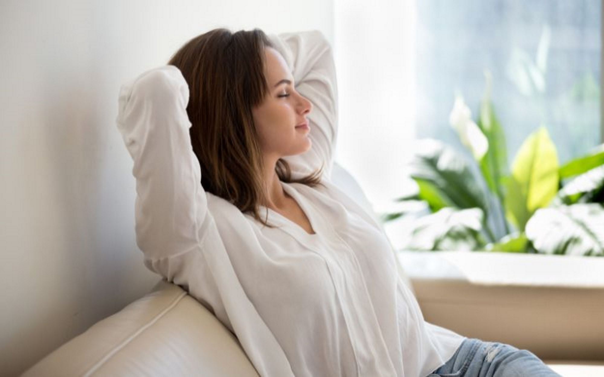 Woman in her house relaxing and breathing in clean air.