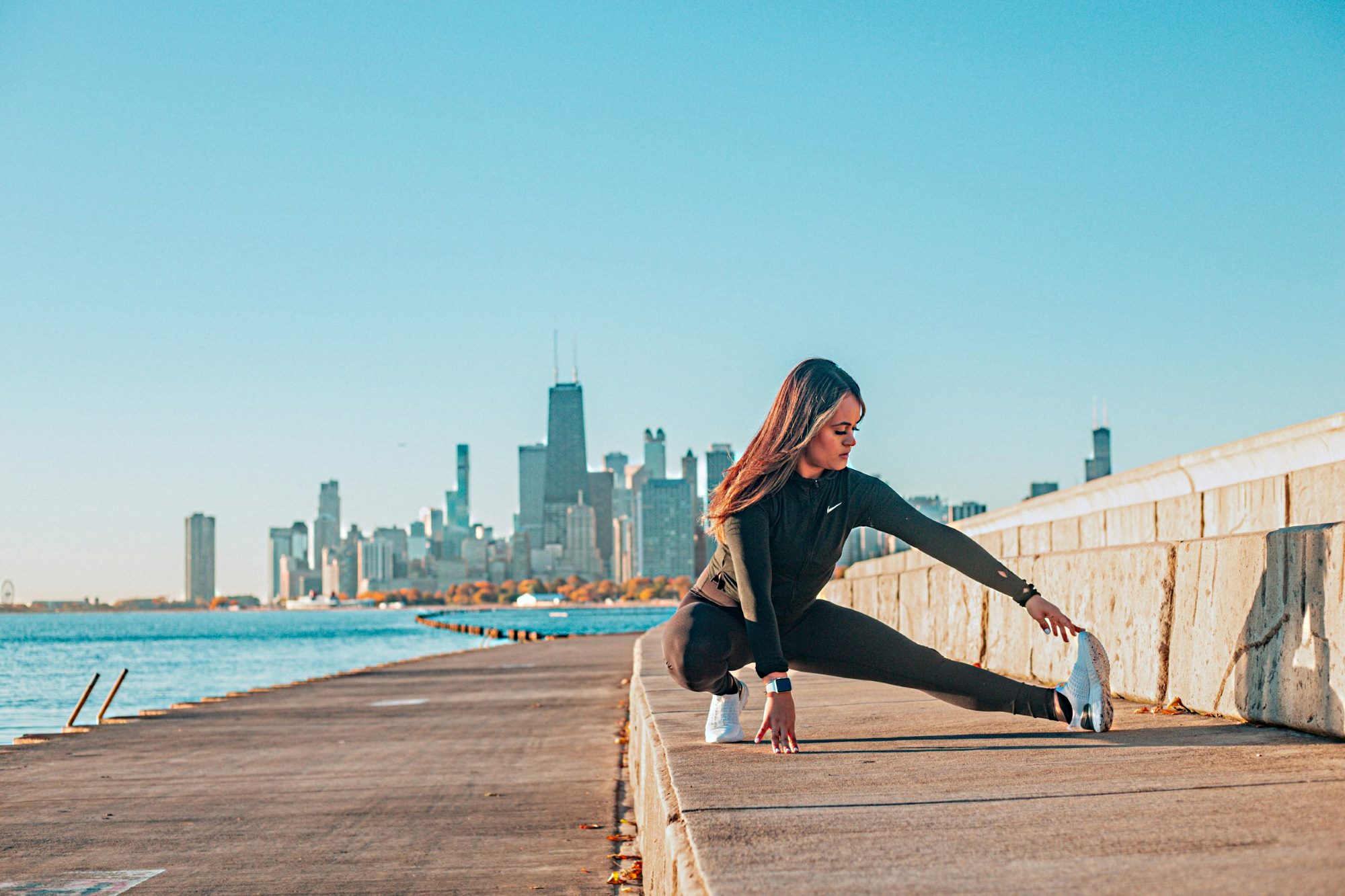 Woman stretching by Chicago lakefront, waterfront. Woman doing a stretching exercise.